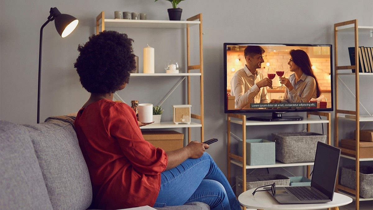 Woman watching TV with Closed Captioning turned on