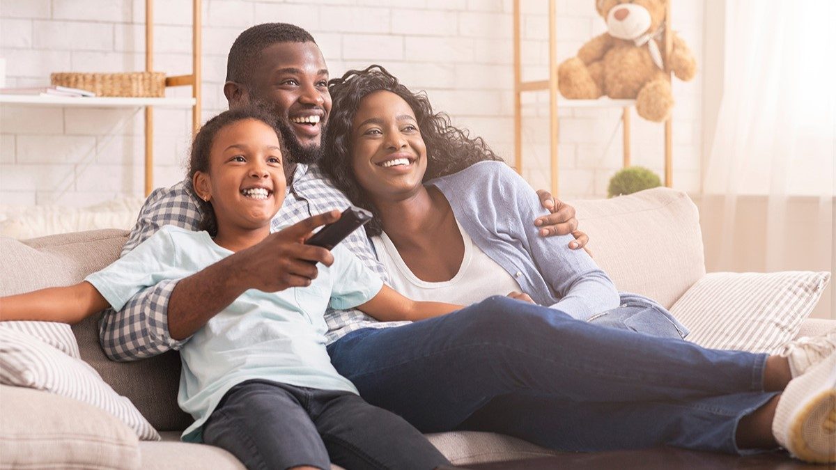 Mother, father and daughter on couch watching a movie with captions turned on Mother, father and daughter on couch watching a movie with captions turned on