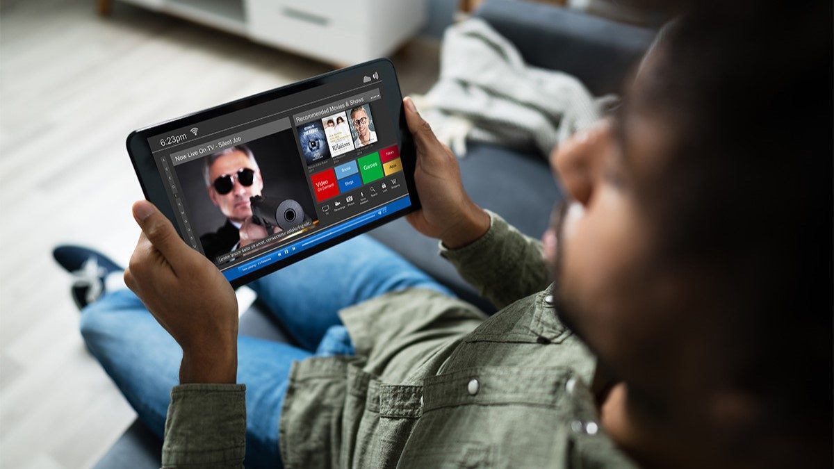 Young man watching streaming content with closed captions turned on on a tablet device Young man watching streaming content with closed captions turned on on a tablet device